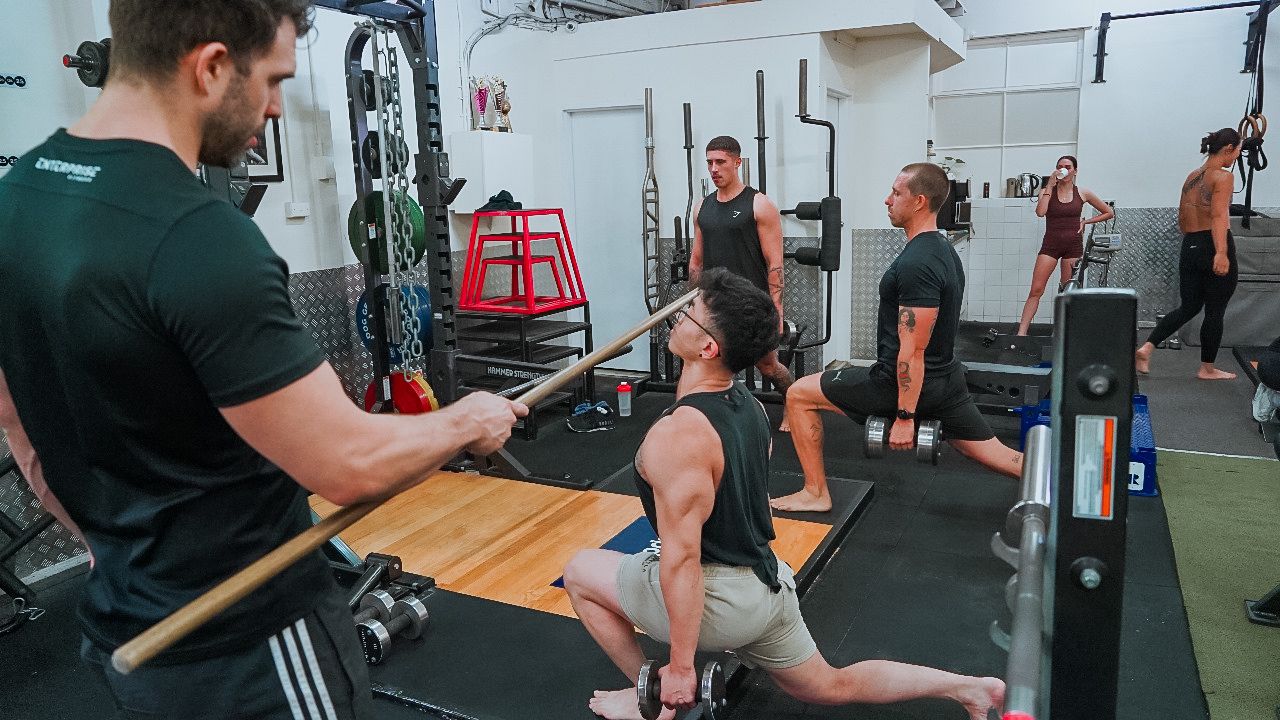 An Enterprise Fitness coach with a client on the gym floor